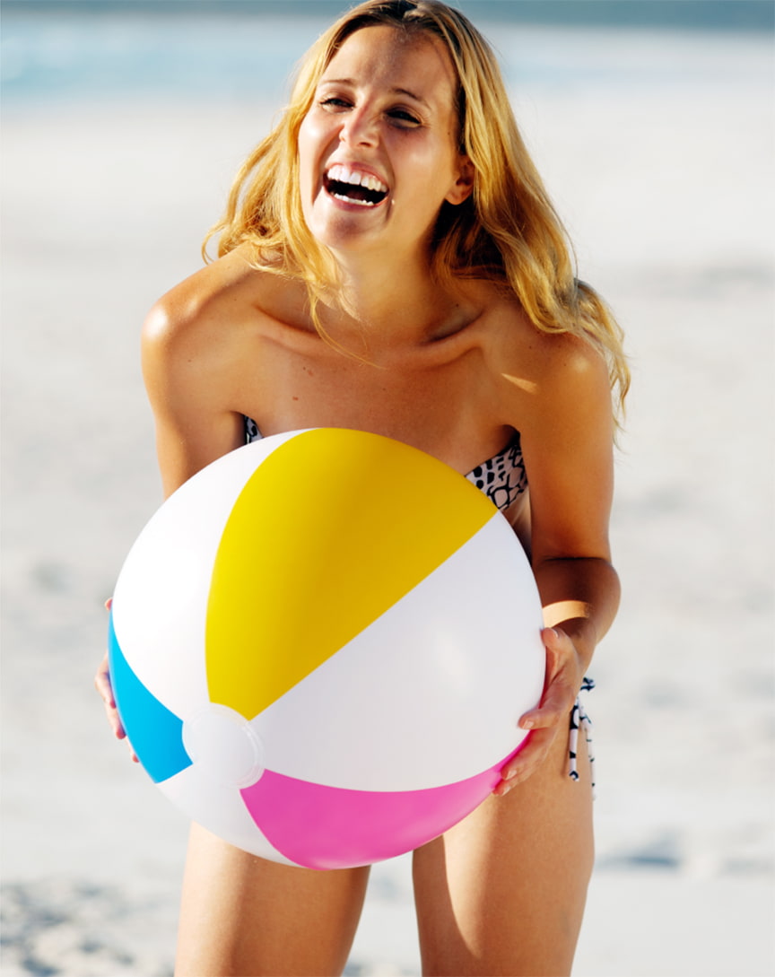 Woman laughing and holding a beach ball