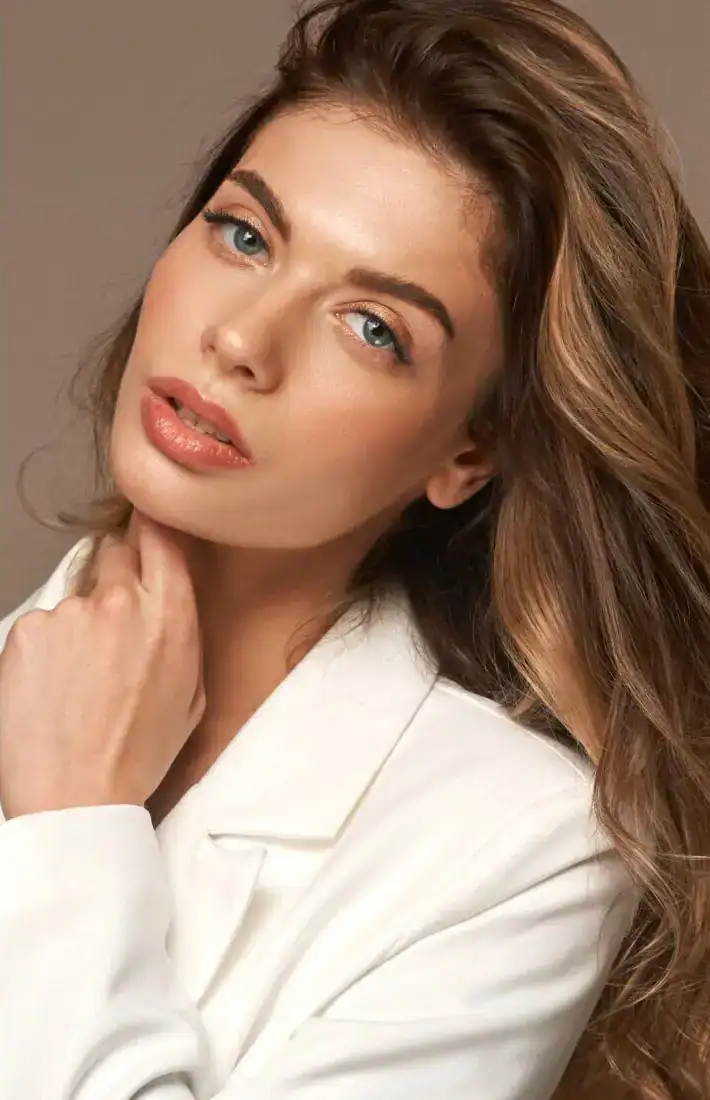 Portrait of woman with smooth, radiant skin and natural makeup in a studio setting.