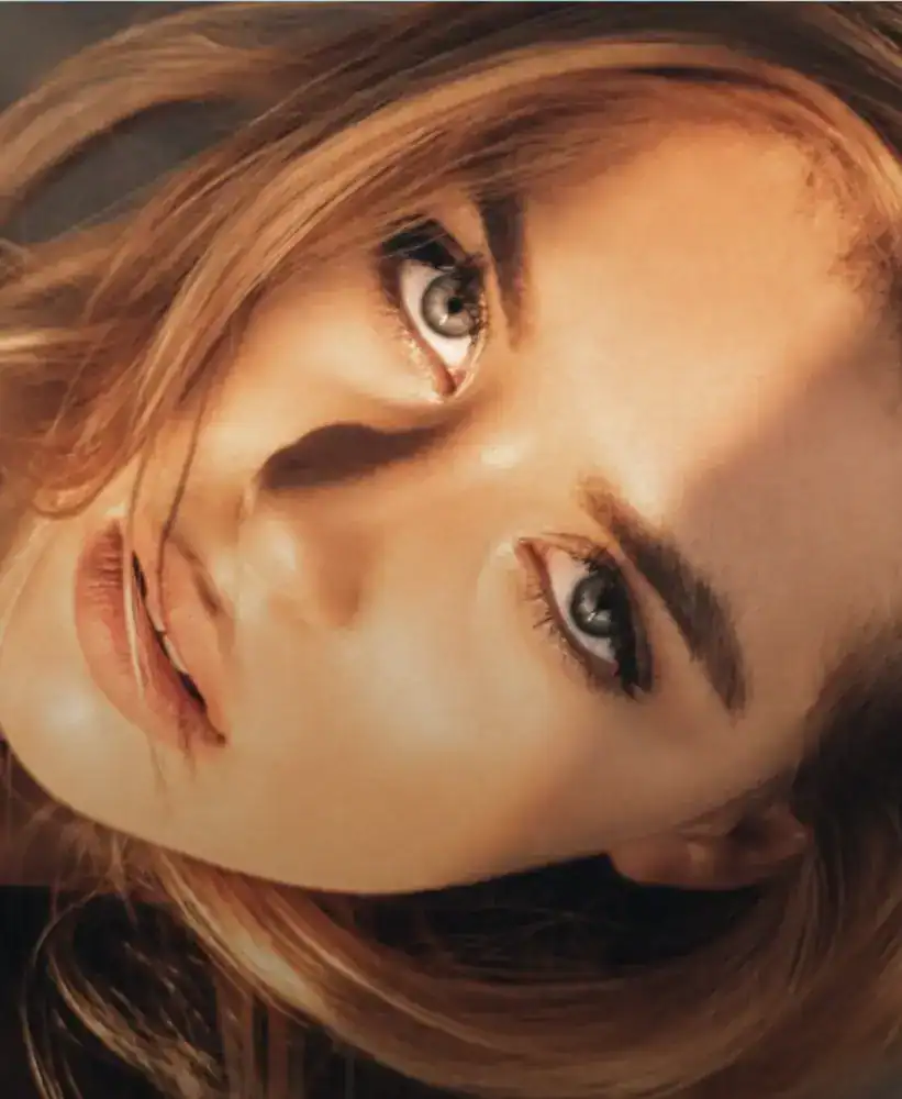 Woman with smooth, glowing skin and natural makeup in warm light.