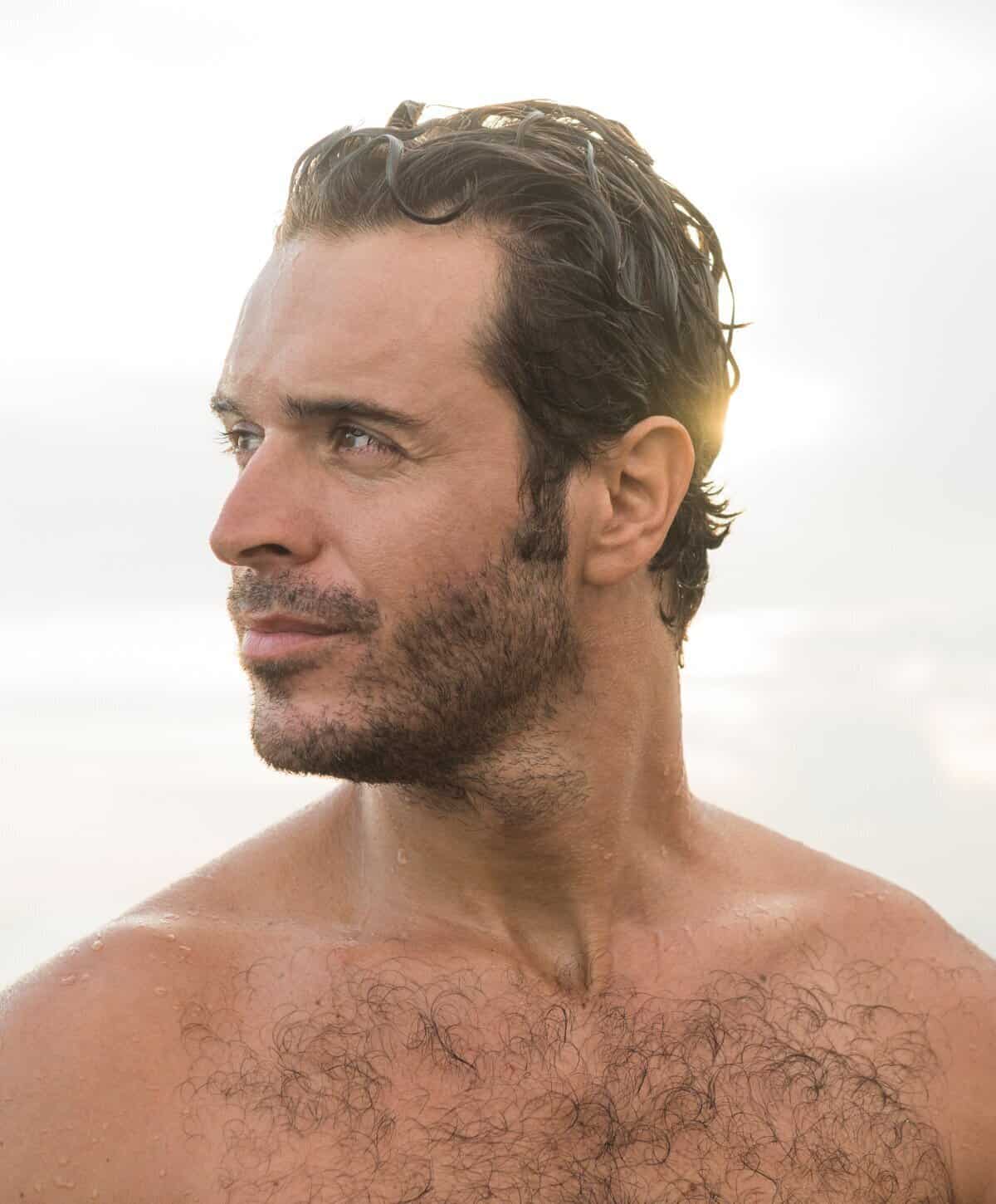 Healthy man at the beach reflecting vitality from testosterone and peptide therapy.