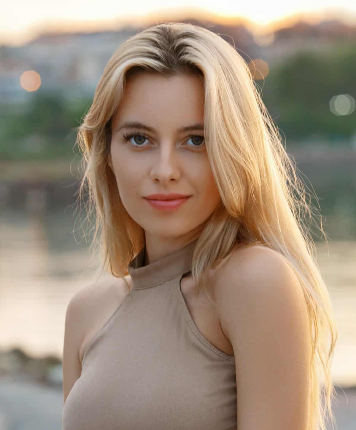Natural beauty portrait of a blonde woman outdoors in soft evening light.