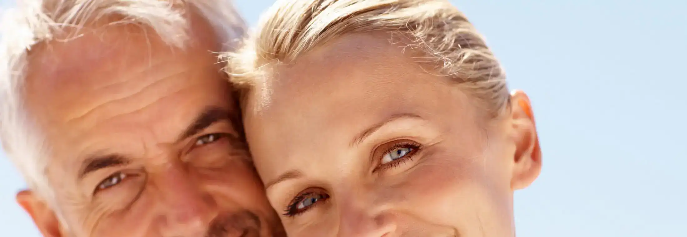 Smiling mature couple enjoying a sunny day outdoors, close-up portrait with natural light