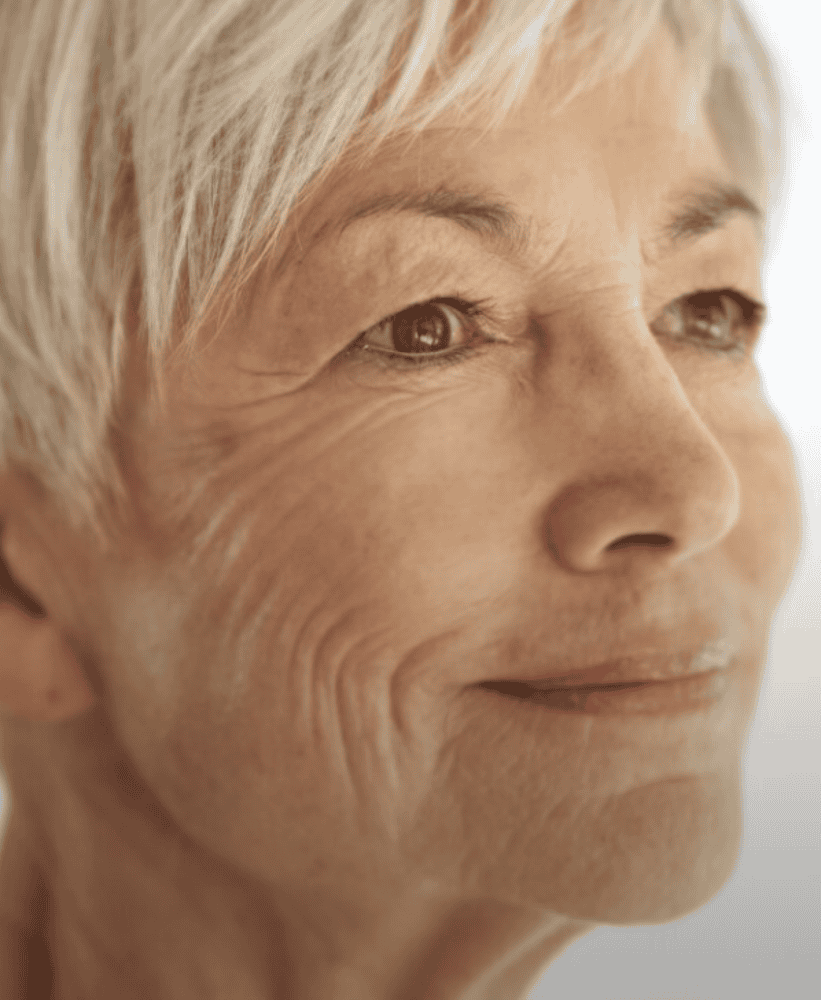 Close-up profile of a mature woman with short silver hair and a gentle smile.