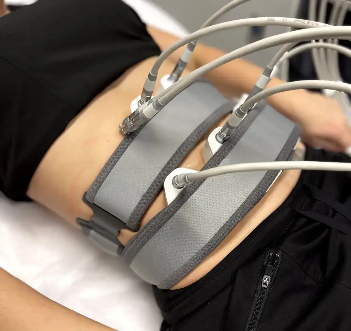 Non-invasive body sculpting and muscle stimulation treatment on a patient's abdomen.