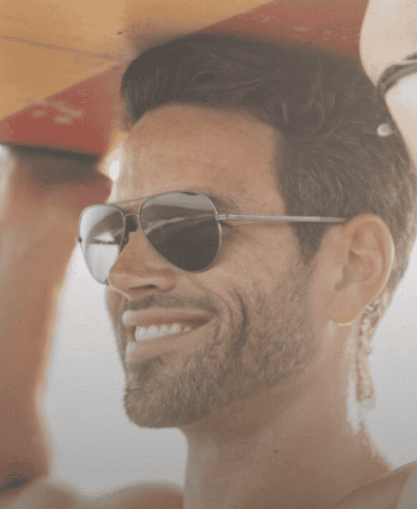 Active lifestyle man carrying surfboard at the beach