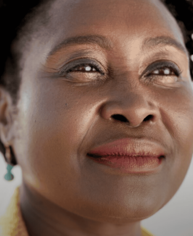 Close-up portrait of a serene woman with a slight smile and turquoise earrings.