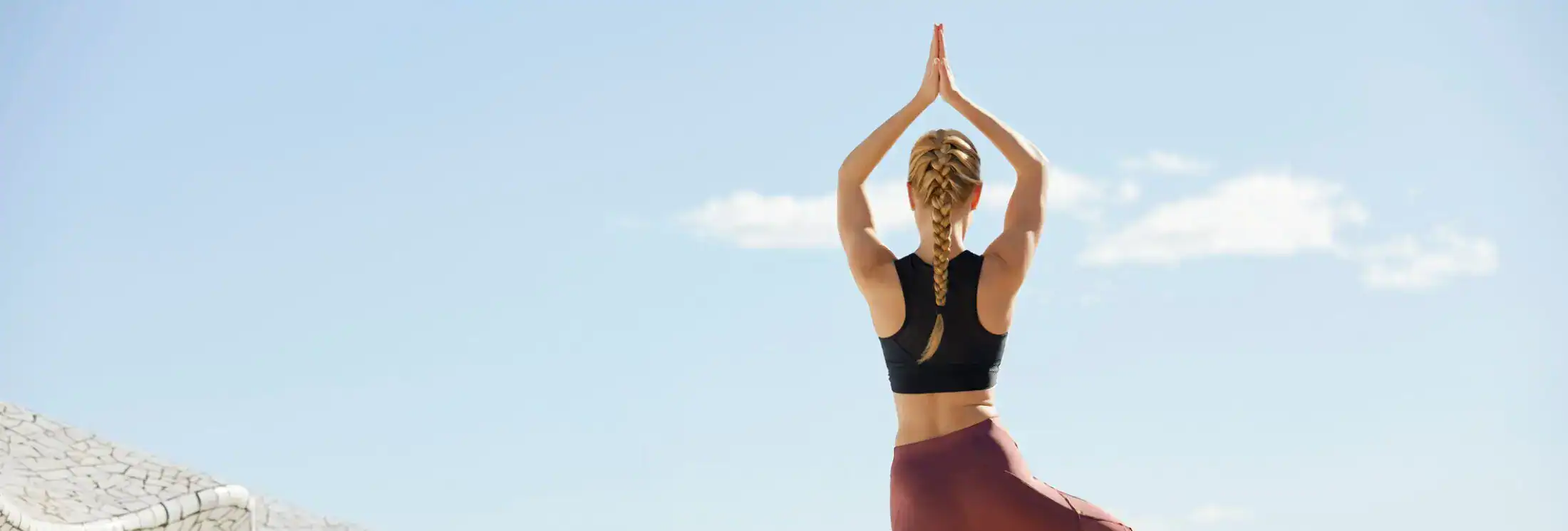 Woman in yoga tree pose outdoors representing balance and hormone health.